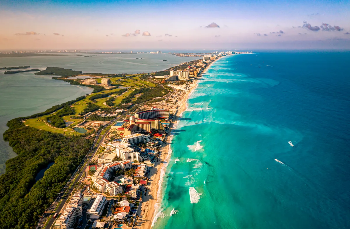 Aerial drone view of the Cancun hotel zone and beach, the busy resort side of the Playa del Carmen vs Cancun choice